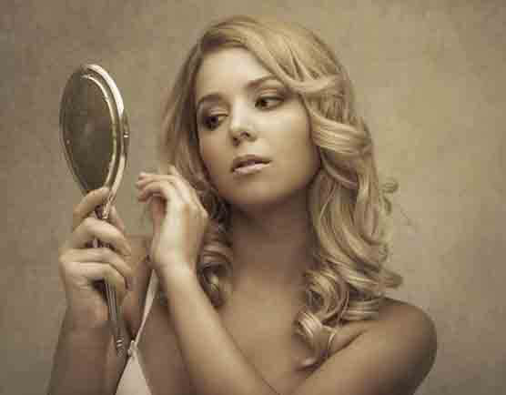 Beautiful woman looking in the mirror