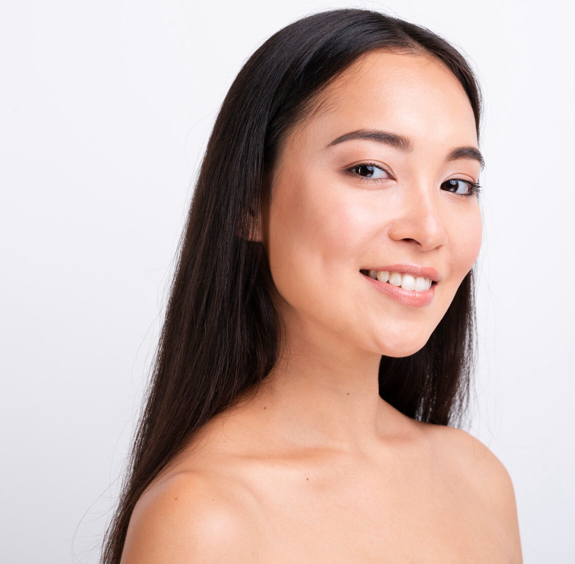 Smiling woman covering one eye with her hand showing natural beauty.