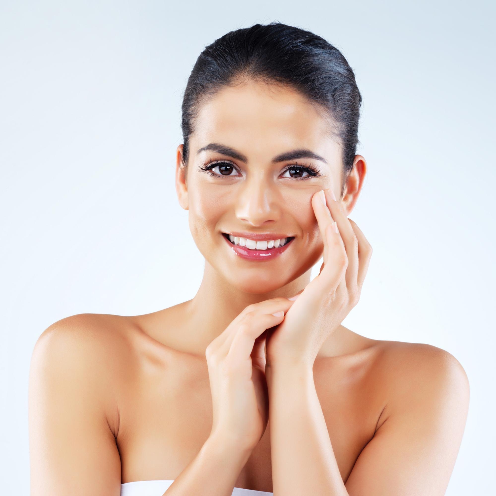 Woman with long light brown hair resting her head on her folded arms over a chair, gazing at the camera.