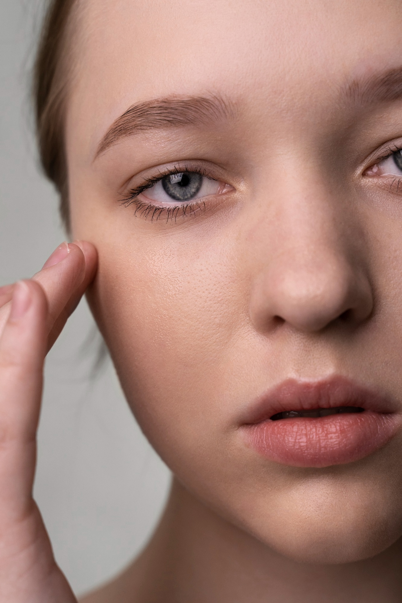 Close-up of a woman applying skincare near the under-eye area.